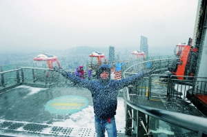 在广州塔顶上游客捧起积雪洒向空中。信息时报记者 陈引 摄