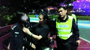 猎德派出所副所长高建峰将女子救上岸之后，海心沙派出所女民警李青怡脱下警服披在该女子身上。信息时报记者 刘军 摄