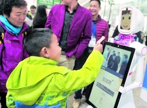 智能机器人“小璐”昨日正式上岗为旅客服务,一名小朋友提问后给“小璐”塞钱,“小璐”回答“为人民服务不收费”。信息时报记者 萧嘉宁 摄