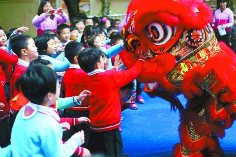 南海机关二幼的孩子正在开心和醒狮互动。 　　/佛山日报记者黄俊波摄