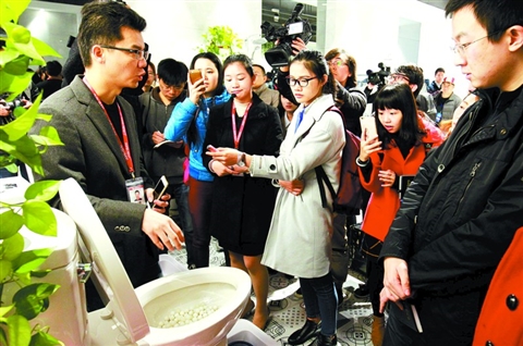昨日，参加“经济活力看广东·转型升级”网上主题采访的媒体记者在东鹏陶瓷展厅参观采访时，被该企业生产的奥斯卡座便器所吸引。/佛山日报记者甘建华摄