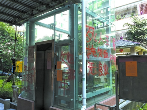 南浦新村24座住宅楼加装的电梯上被人用红漆涂字催款。