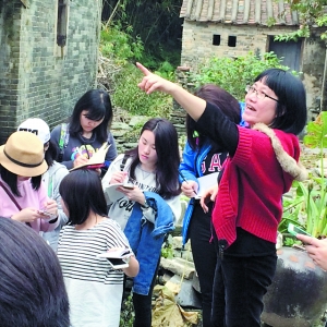 谭金花（右一）在仓东村向学生介绍华侨历史。