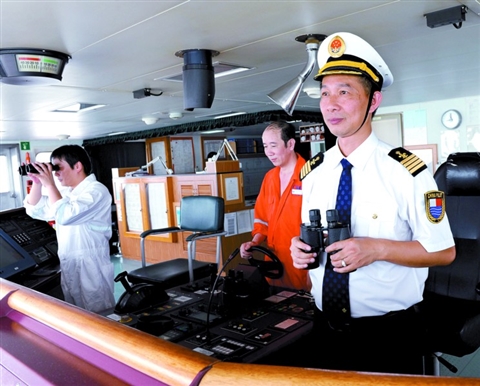广州港高级引航员卢沙（右一）为船舶引航。/受访者供图
