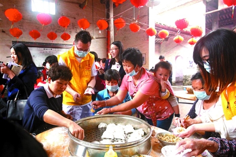 昨日上午，更合镇举办的第六届角仔节上，朗锦村村民与志愿者一起在包角仔。/图片均为佛山日报记者黎汉沿摄