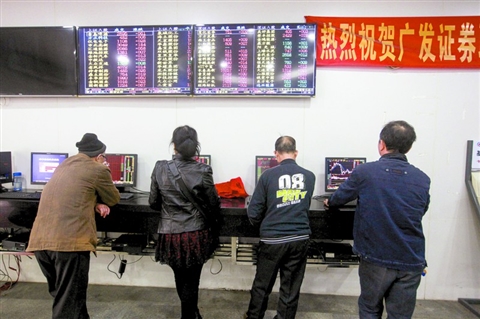 昨日，在南海区桂城街道天佑三路一家证券营业厅内，股民在电脑上查询股票价格。/佛山日报记者王伟楠摄