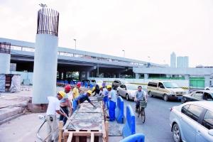 艺洲路经过广州大桥底西往东方向,一条车道被封闭,多位工人在现场忙碌施工。
