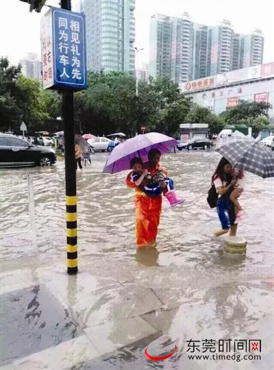 环卫工人抱着学生通过水浸路。通讯员 莫艳芬 供图