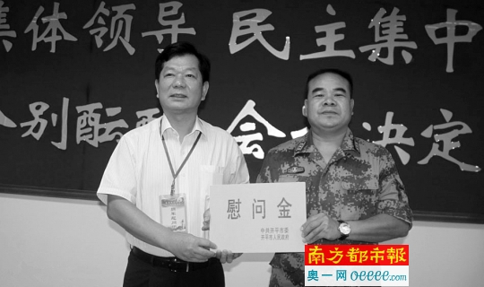 → 开平市委书记黄耀雄(左)向开平市人武部送上慰问金。