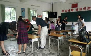 爱心人士、企业代表等在教室里正忙于黑板改造等工作。