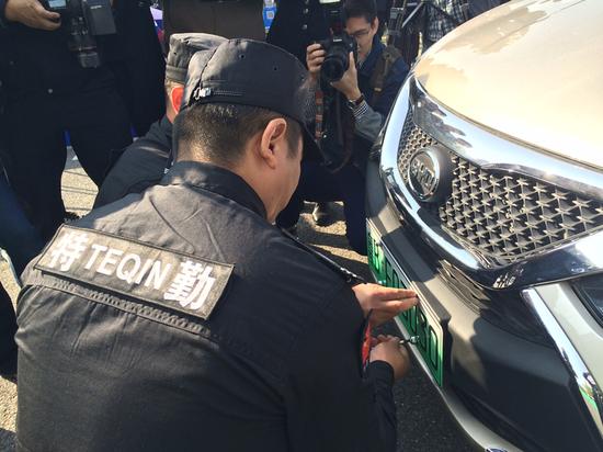 图为工作人员在安装全市首张新能源汽车号牌。 深圳晚报记者 胡琼兰 摄