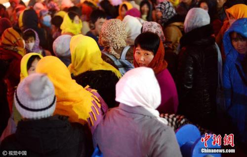 资料图 山东省济南市，多名农民工聚集在路口处，站在寒风中寻找工作。 御宁 