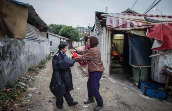 林伟强是一名残疾人，如今是塘夏莲湖社区的辅警，他的妈妈从前与黄孟益一起在街边卖菜，这天他给老人家送来两百块钱，老人家坚决不肯收。