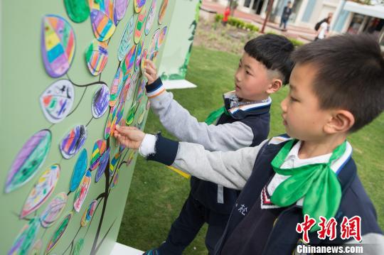 小朋友参与上海迪士尼度假区地球月活动，写下节约用纸的承诺