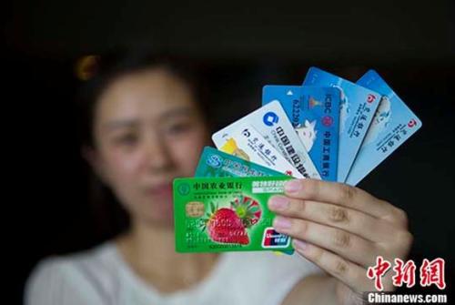 资料图:民众展示银行卡。中新社记者张云摄