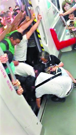 一名乘客在车厢里帮助女乘客把右腿拔出来。