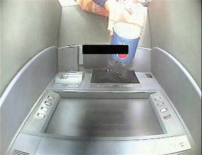 女子轻信骗子的话,以为往取款机里倒可乐能取回钱。本报记者甘侠义 摄
