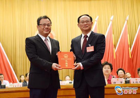 江门市委书记、市人大常委会主任林应武为新当选的市长刘毅颁发当选证。梁文悦摄