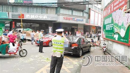 蓬江交警大队一中队民警对乱停乱放车辆进行拍照取证。