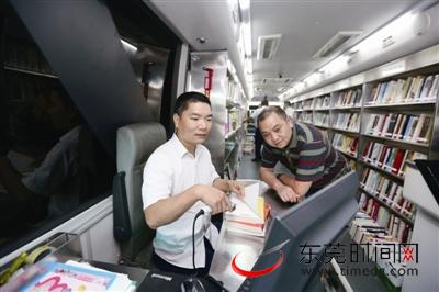 图书流动车上的工作人员为借书的市民服务
