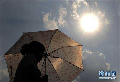 7月4日，广州街头的行人纷纷打起遮阳伞。当日，广州最高气温达到36℃。新华社记者 卢汉欣 摄