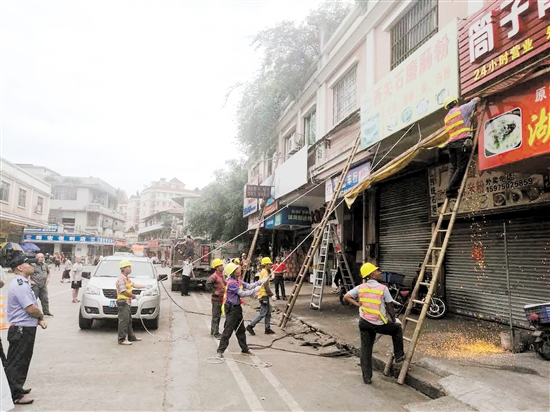 联合执法队组织清拆小范街两边商铺的违章搭建物。