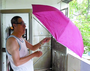 老人展示小伙给的雨伞。
