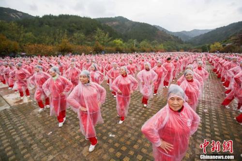 资料图:武汉大妈们冒雨同跳广场舞。 张畅 摄