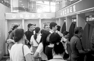 6月27日,解放南路出入境大厦,市民在自助办证区排队办证。