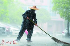 石龙儿童医院，一名环卫工人在暴雨中工作。