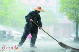 石龙儿童医院,一名环卫工人在暴雨中工作。
