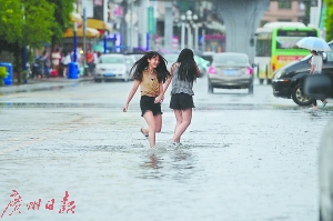 两名女子在小雨中涉水前行。