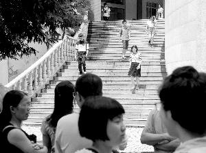 　　参加完面试的学生走下台阶，有亲友正在等候他们。