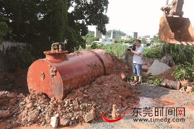 埋在泥土下的大油罐被挖起 本版图片均由记者 陈栋 摄