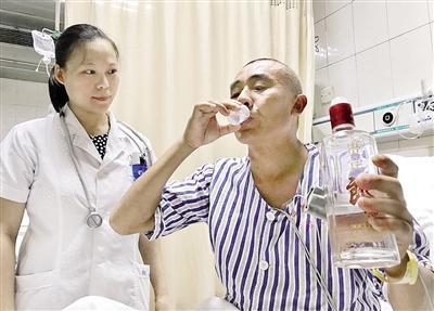 昨日，傅先生在医生指导下，喝白酒解毒。 本报记者 杨新宇 摄