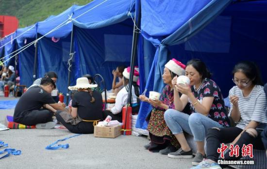 8月10日,四川九寨沟“8.8”地震震源中心附近的临时安置点,受灾村民在帐篷边吃饭。<a target='_blank' href='http://www.chinanews.com/'>中新社</a>记者 刘忠俊 摄 8月10日,四川九寨沟“8.8”地震震源中心附近的临时安置点,受灾村民在帐篷边吃饭。中新社记者 刘忠俊 摄
