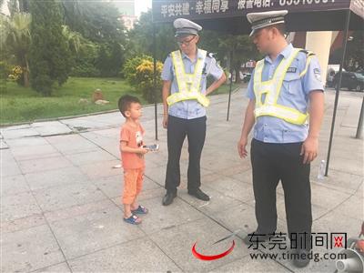 大朗镇嘉荣天桥路口，执勤协管员正在帮忙寻找小男孩家人 通讯员供图