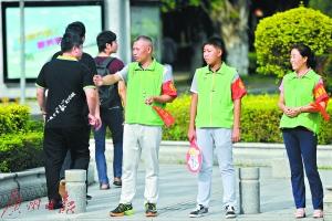周忠和妻子陶霞及儿子小周在街头维持交通秩序。广州日报全媒体记者葛宇飞摄