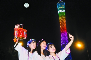 一群来自河南的游客正在明月下和广州塔合影,她们说“广州太美啦!”(二次曝光)广州日报全媒体记者王燕 摄
