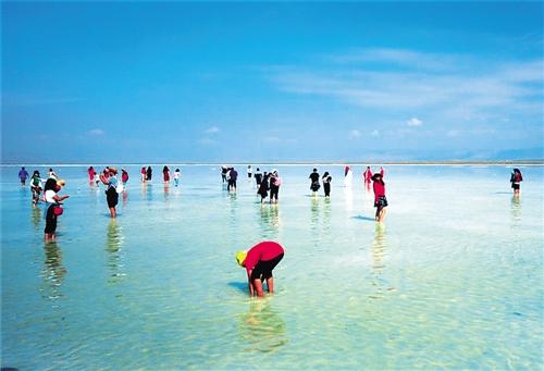 游客在青海茶卡盐湖漫步游玩