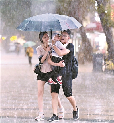 一场暴雨让伞下的一家三口更加亲密。广州日报全媒体记者黎旭阳摄