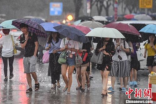 广州民众在暴雨中出行。 中新社记者 陈骥旻 摄
