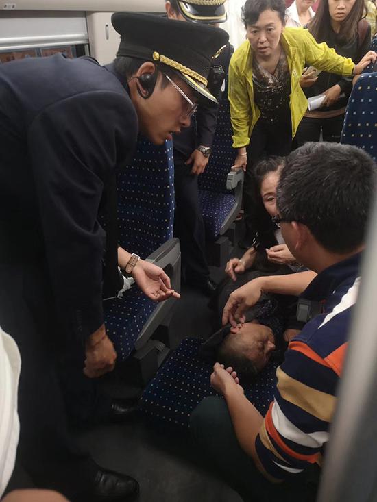 7月24日晚，一位老人在高铁上突发疾病晕倒，谢敏崇前去施救。 本文图片 采访对象提供