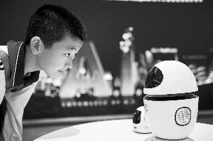 在科大讯飞公司的展示厅里，一名学生饶有兴趣地观察人工智能机器人。信息时报记者 陆明杰 摄