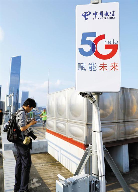 上图：近日，中国电信5G创新合作大会上，工作人员向嘉宾介绍5G的相关产业。 下图：近日，媒体记者在电信大楼体验5G信号。深圳商报记者 钟华登 摄