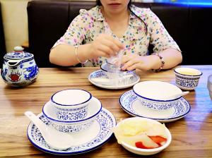 金菊路上某菜馆,客人把消毒碗筷撕开清洗。