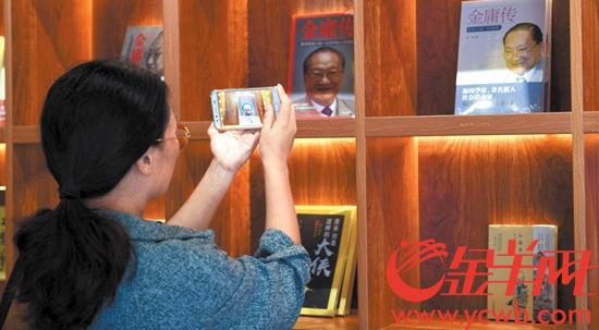 10月31日，浙江海宁，一位参观者在拍摄金庸作品及《金庸传》 图/视觉中国
