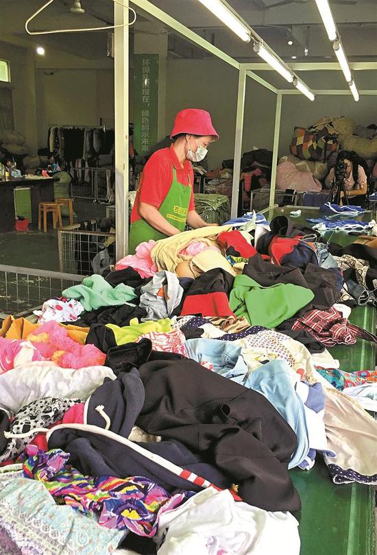 流水线上,工作人员正麻利地对旧衣服进行分拣。
