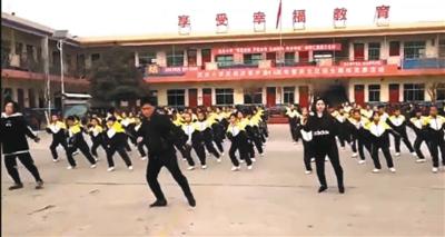 网络视频显示,校长张鹏飞在学校操场带领学生跳舞。视频截图