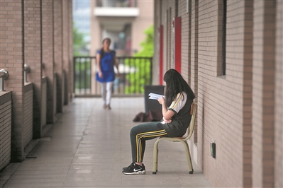 万江中学，一名学生在走廊上静静地复习。